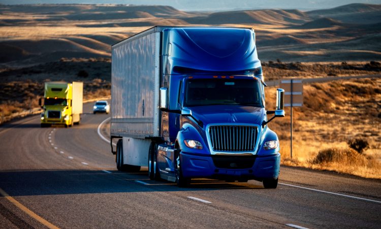 Long Haul Semi-Truck Rolling Down a Four-Lane Highway at Dusk